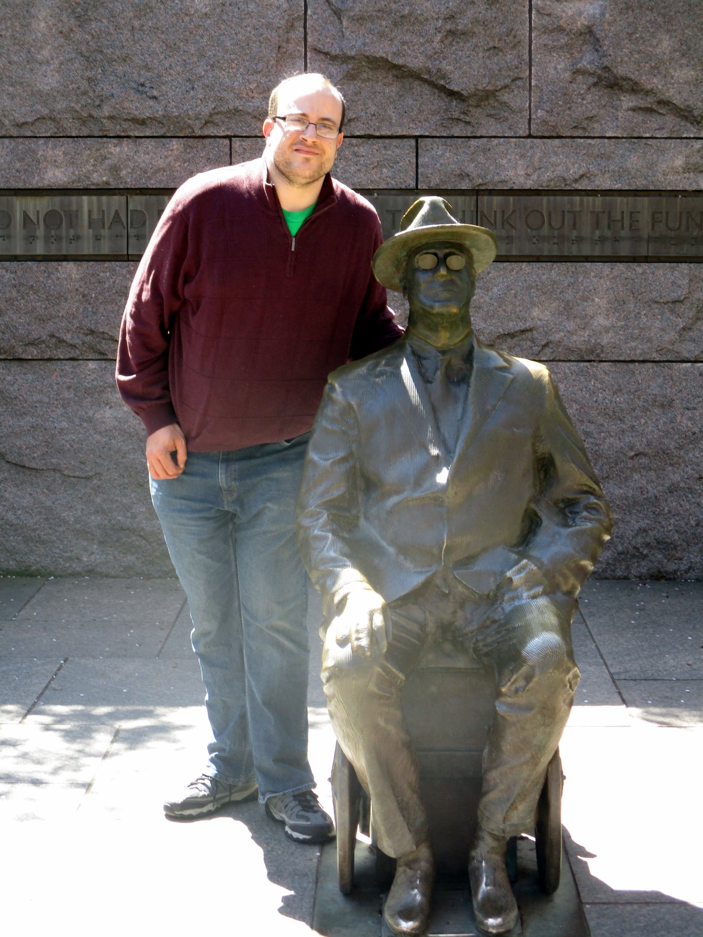 Alec Frasier standing next to FDR wheelchair statue